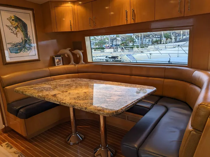  Yacht Photos Pics Luxurious dining area inside a 2001 Hatteras 70 Convertible yacht with granite table and leather seating.