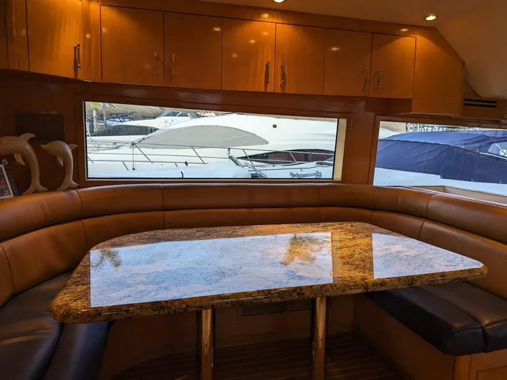  Yacht Photos Pics Luxurious dining area inside a 2001 Hatteras 70 Convertible yacht with a granite table.