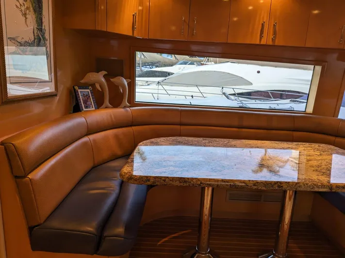  Yacht Photos Pics Luxurious dining area inside a 2001 Hatteras 70 Convertible yacht with a marina view.