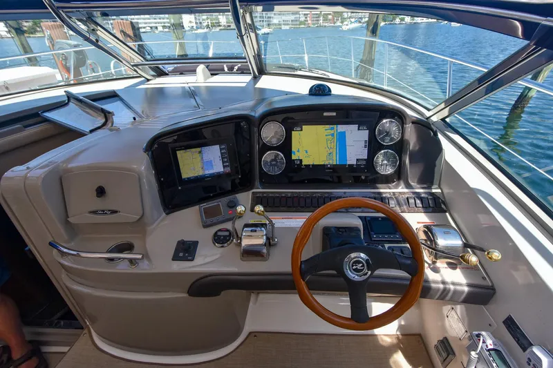 Pure Fun Yacht Photos Pics 2007 Sea Ray 40 Sundancer helm with navigation screens and wooden steering wheel.