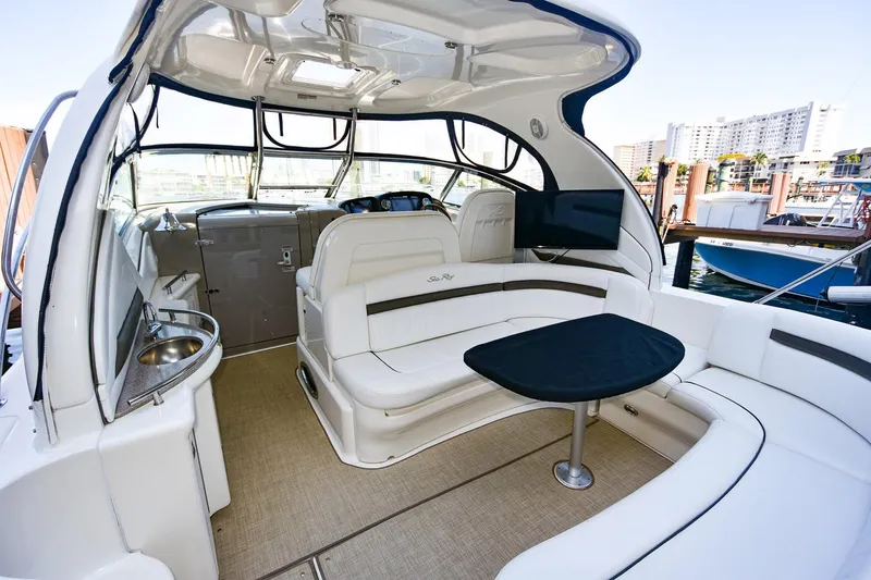 Pure Fun Yacht Photos Pics Luxurious 2007 Sea Ray 40 Sundancer yacht interior with seating and table, docked at marina.