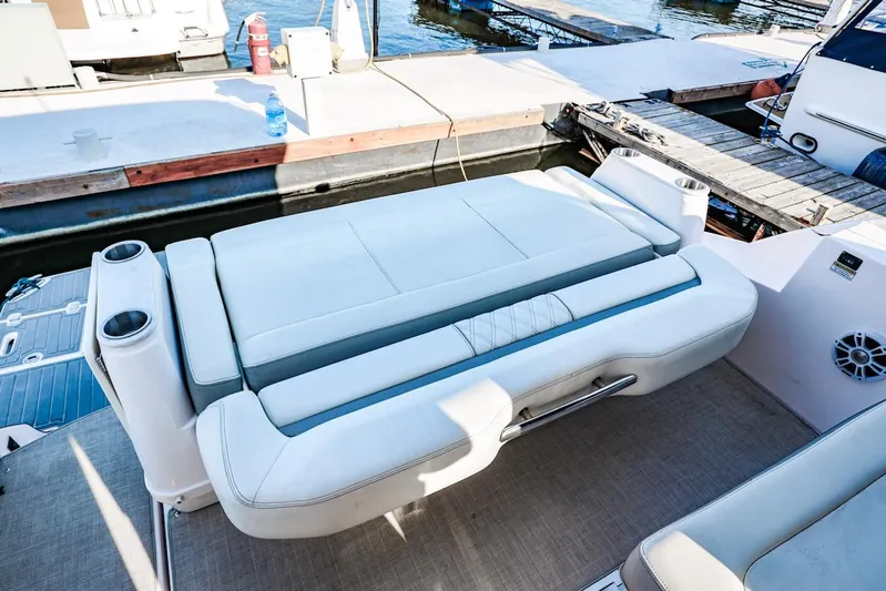 Yacht Photos Pics 2021 Regal 36 Grande Coupe boat with luxurious seating and cup holders at a marina.