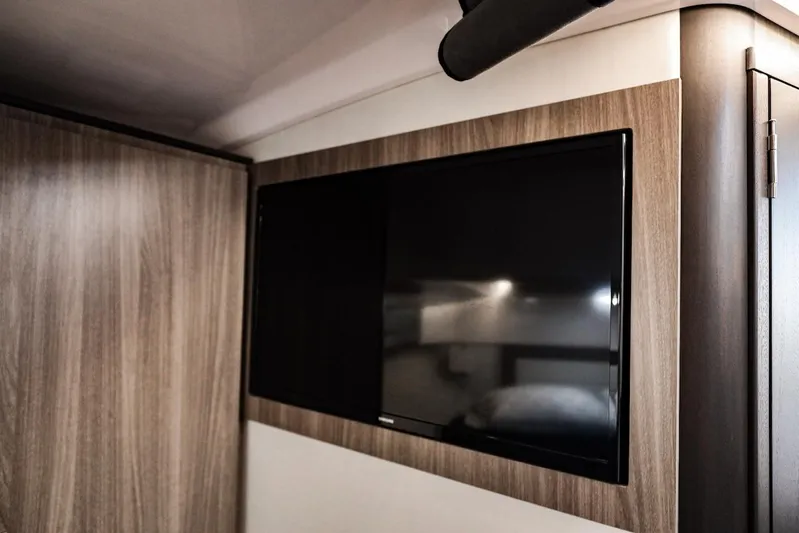  Yacht Photos Pics Flat-screen TV in 2021 Regal 36 Grande Coupe interior with wood paneling.