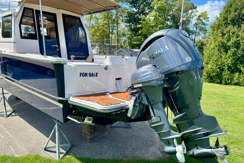  Yacht Photos Pics 2025 Ranger Tugs R-27 boat for sale with Yamaha outboard motor, displayed on stands.