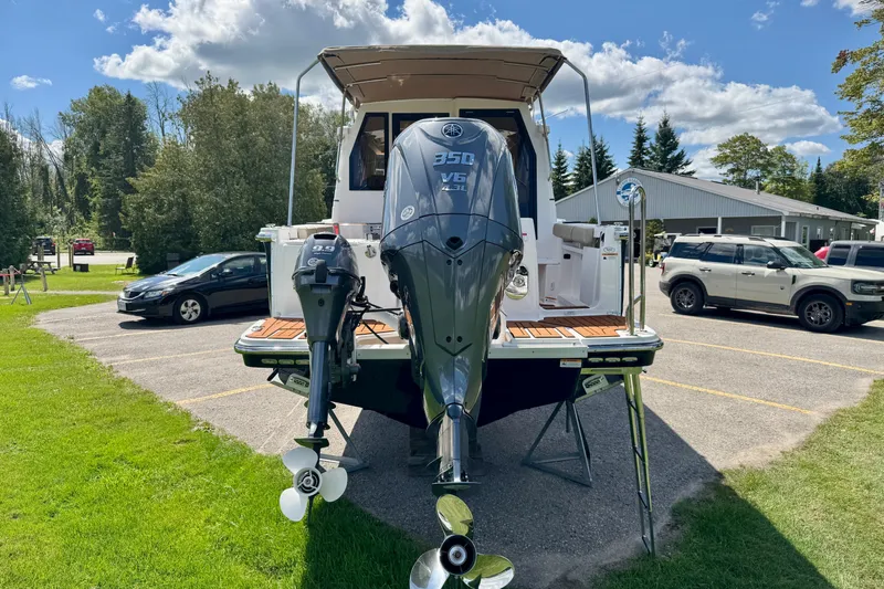  Yacht Photos Pics 2025 Ranger Tugs R-27 boat with dual outboard motors in a parking area.