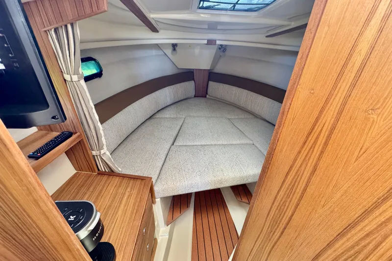  Yacht Photos Pics 2025 Ranger Tugs R-27 cabin interior with cozy bed and wooden accents.