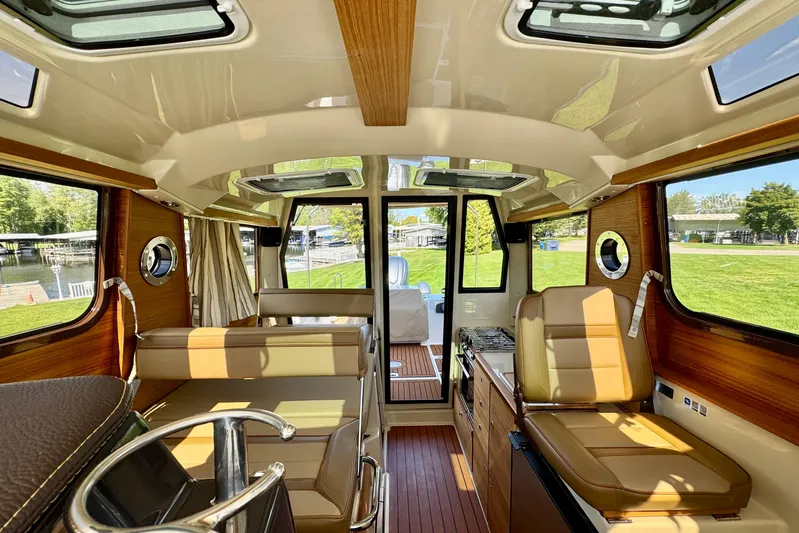  Yacht Photos Pics Interior of 2025 Ranger Tugs R-27 boat, featuring luxurious seating and wood accents.