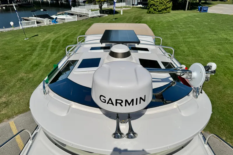  Yacht Photos Pics 2025 Ranger Tugs R-27 boat with Garmin equipment, docked near a grassy area.