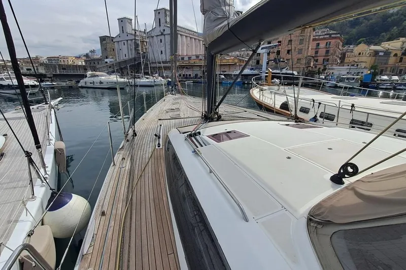  Yacht Photos Pics CNB BORDEAUX 60 yacht docked in a scenic marina, showcasing elegant design and craftsmanship.