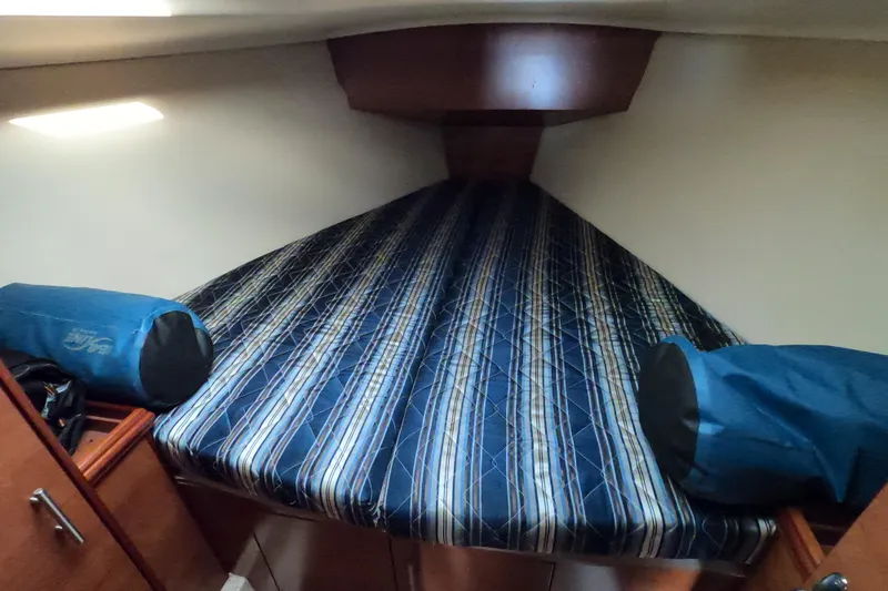 Moon Shadow Yacht Photos Pics 2013 Marlow-Hunter e33 cabin interior with striped bedding and storage compartments.