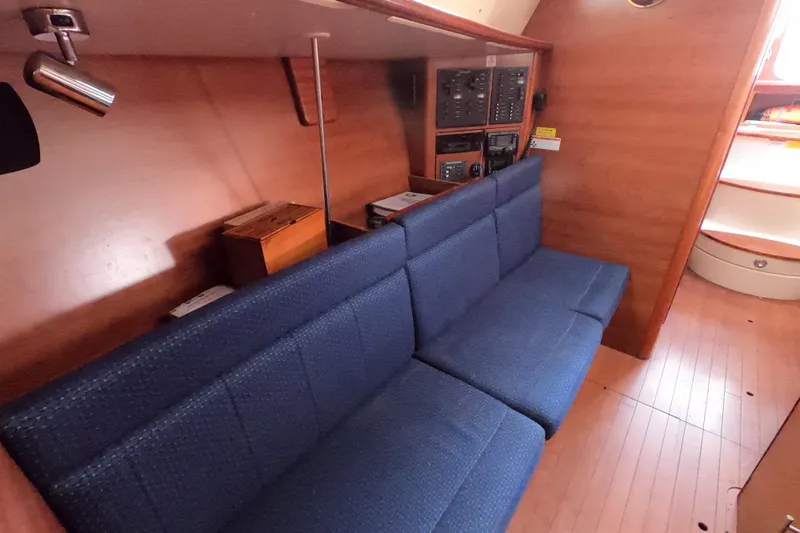Moon Shadow Yacht Photos Pics Interior of 2013 Marlow-Hunter e33 sailboat with blue seating and wooden paneling.