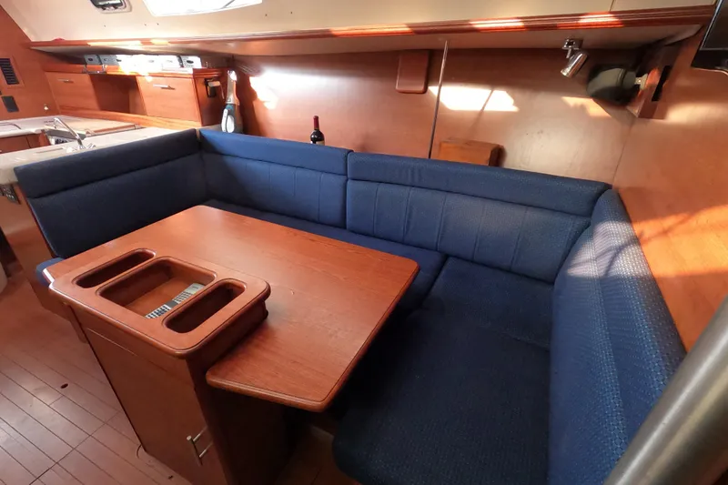 Moon Shadow Yacht Photos Pics 2013 Marlow-Hunter e33 yacht interior with blue cushioned seating and wooden table.