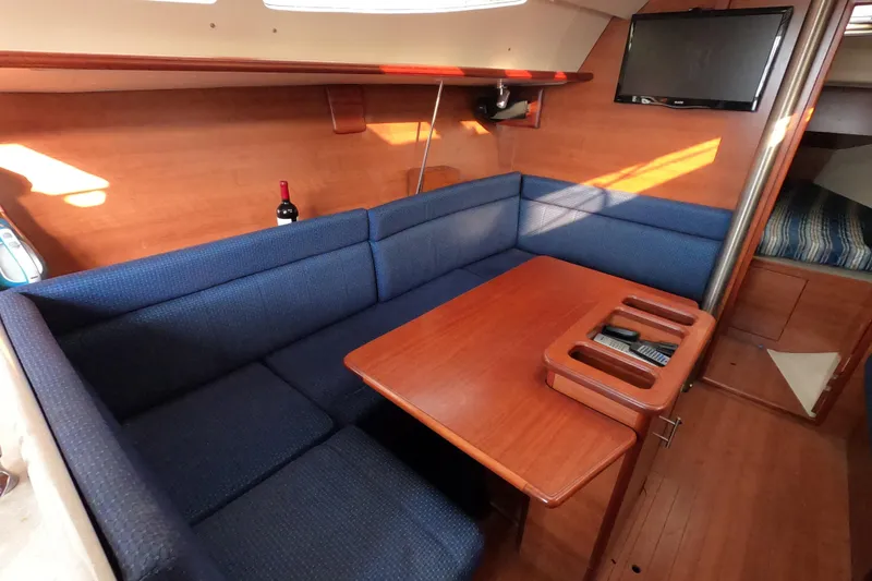 Moon Shadow Yacht Photos Pics Interior of 2013 Marlow-Hunter e33 sailboat with blue seating and wooden table.