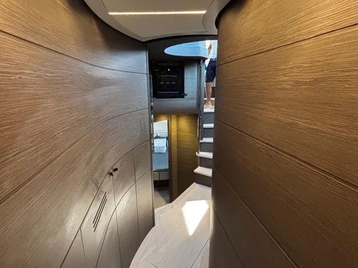  Yacht Photos Pics Interior hallway of 2019 Pershing 74 yacht with wooden paneling and staircase.