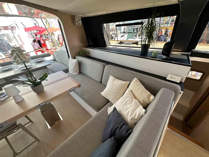  Yacht Photos Pics Modern interior of 2025 NEEL 52 yacht with cozy seating and dining area.