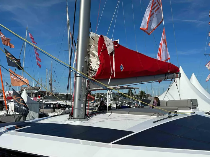  Yacht Photos Pics Sailing yacht NEEL 52, 2025 model, with red sail and flags at marina.