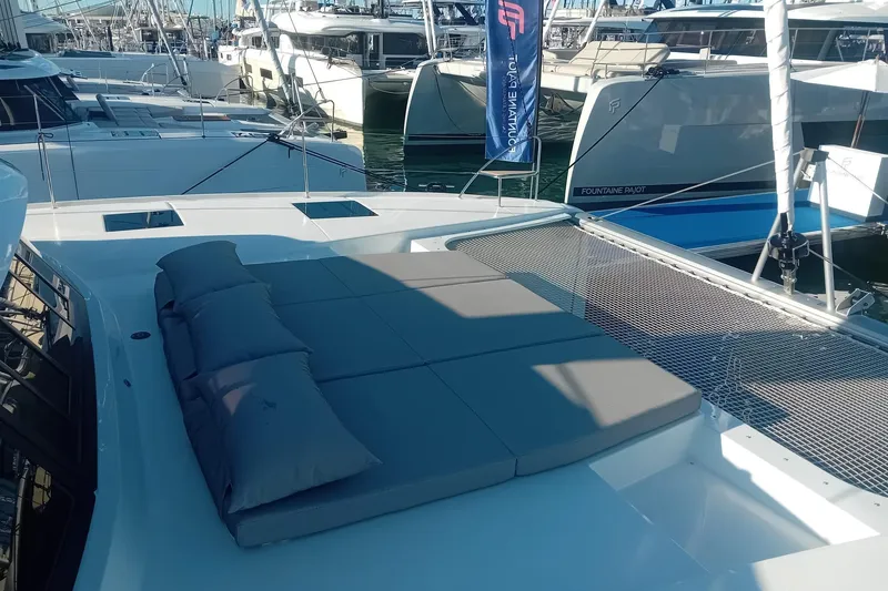  Yacht Photos Pics 2024 Fountaine Pajot Tanna 47 catamaran with sunbathing area and netting at marina.
