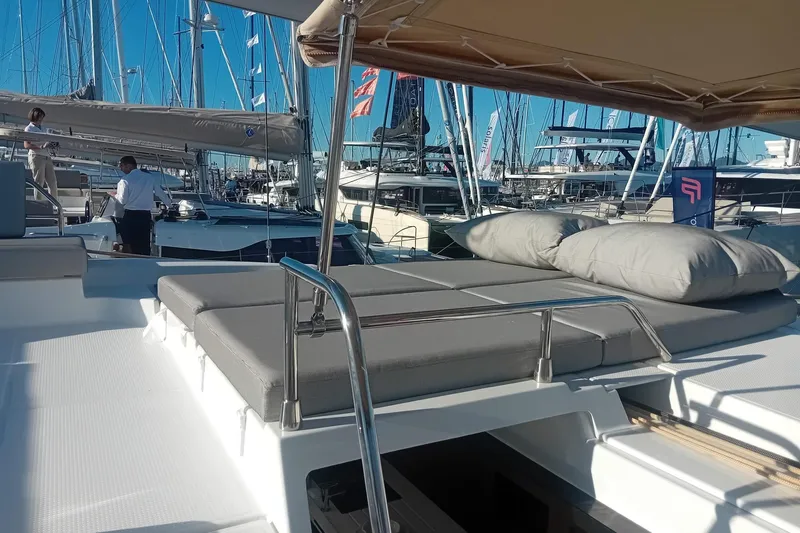  Yacht Photos Pics 2024 Fountaine Pajot Tanna 47 catamaran with sunbathing area at a marina.