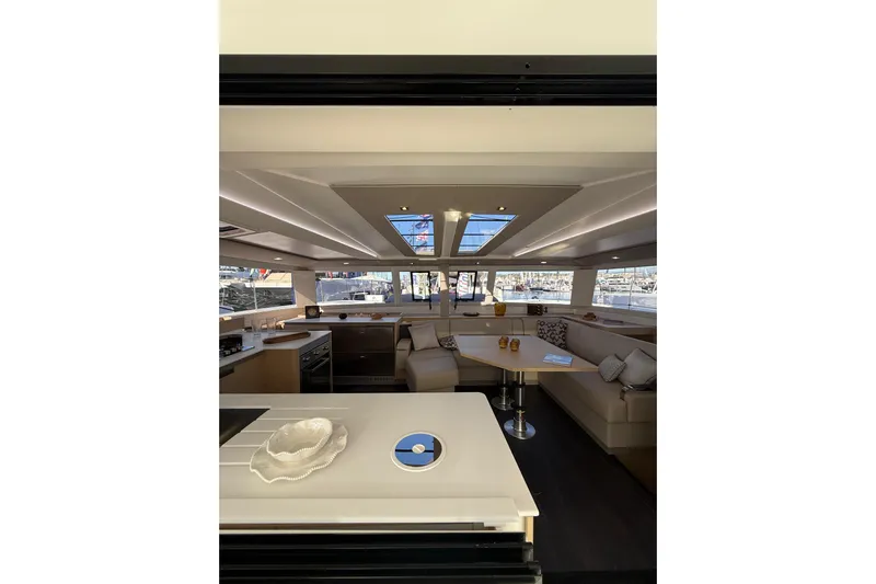  Yacht Photos Pics Luxurious interior of 2024 Fountaine Pajot Tanna 47 catamaran with modern kitchen and seating area.