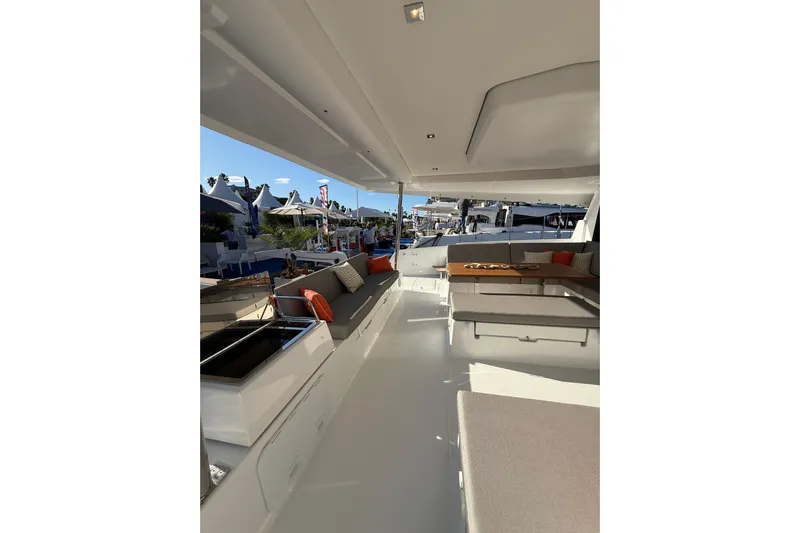  Yacht Photos Pics 2024 Fountaine Pajot Tanna 47 yacht interior with seating and table, docked at marina.