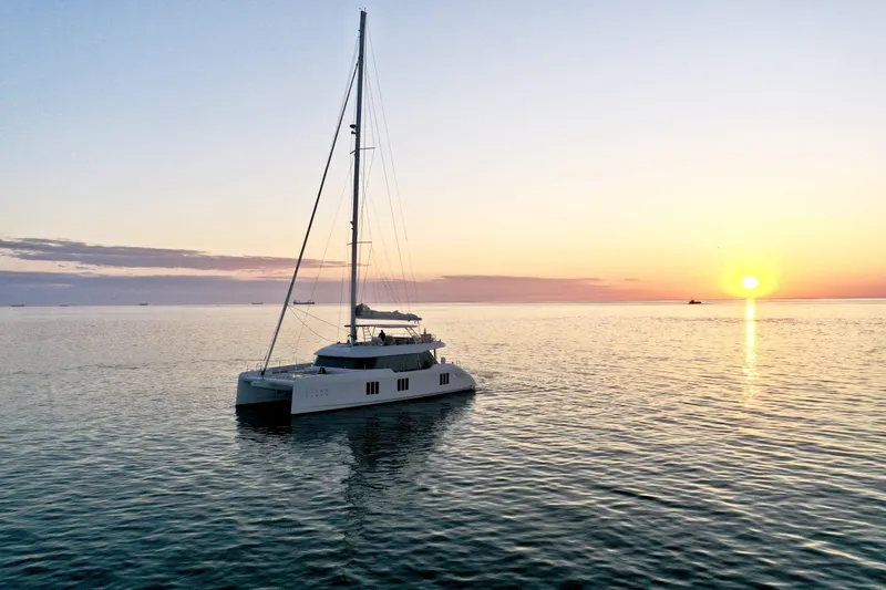  Yacht Photos Pics Sunreef 70 yacht sailing at sunset, 2026 model, on calm ocean waters.