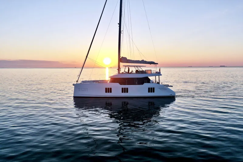  Yacht Photos Pics 2026 Sunreef 70 yacht sailing at sunset on calm ocean waters.