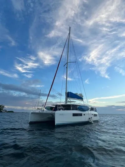 Nice Aft Too Yacht Photos Pics 2018 Leopard 45 catamaran sailing on calm ocean under a vibrant sky.