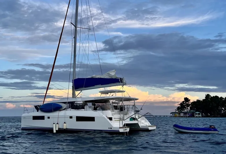 Nice Aft Too Yacht Photos Pics Sailing catamaran Leopard 45, 2018 model, anchored near a scenic island at sunset.