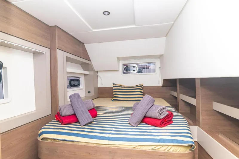 Dreamer Yacht Photos Pics Cozy cabin interior of 2022 Bali 4.6 yacht with striped bedding and folded towels.
