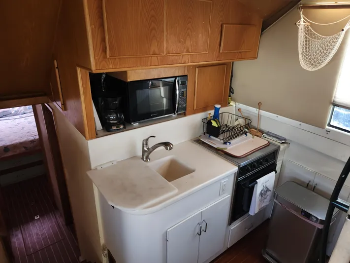 Boss Lady Yacht Photos Pics Compact kitchen in a 2001 Ocean Yachts 48, featuring a sink, stove, and microwave.