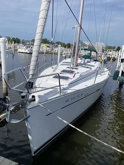 Axis Mundi Yacht Photos Pics 2002 Beneteau 393 sailboat docked in a marina, showcasing sleek design and white hull.