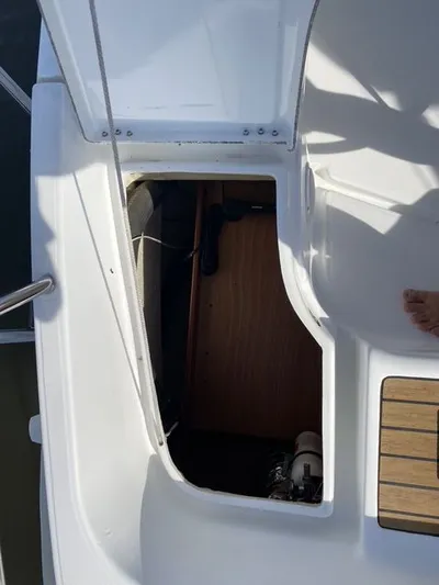 Axis Mundi Yacht Photos Pics Open hatch on 2002 Beneteau 393 sailboat deck, revealing interior storage space.