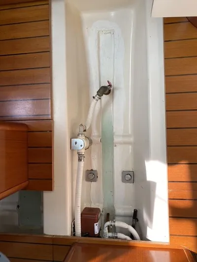 Axis Mundi Yacht Photos Pics Interior view of a 2002 Beneteau 393 sailboat, showing plumbing and wooden paneling.