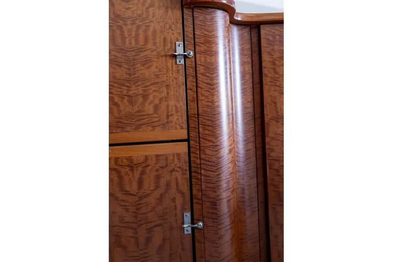  Yacht Photos Pics Wooden interior paneling of a 1997 Garlington Convertible, featuring elegant grain and metal hinges.