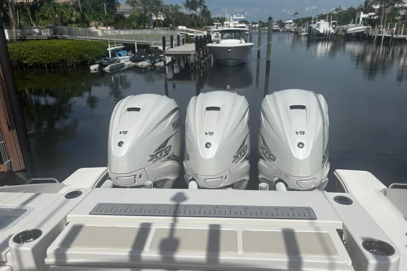  Yacht Photos Pics 2021 Pursuit S 378 Sport boat with triple Yamaha V8 outboard engines docked by a canal.