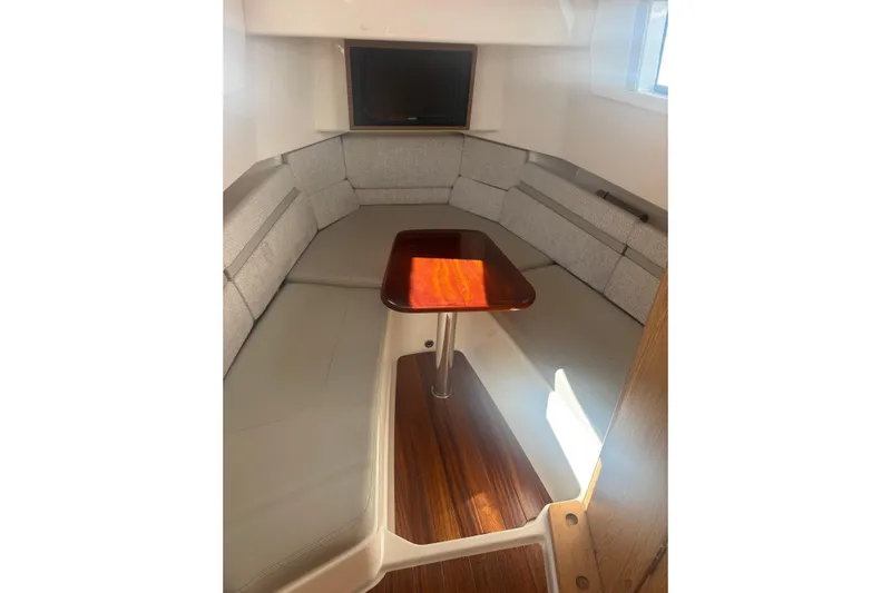  Yacht Photos Pics 2021 Pursuit S 378 Sport cabin interior with cushioned seating and wooden table.