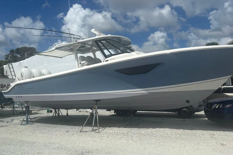  Yacht Photos Pics 2021 Pursuit S 378 Sport boat on stands under a cloudy sky.