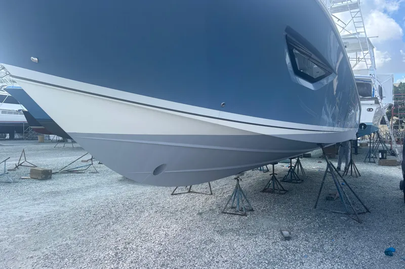  Yacht Photos Pics 2021 Pursuit S 378 Sport boat on stands in a gravel yard.