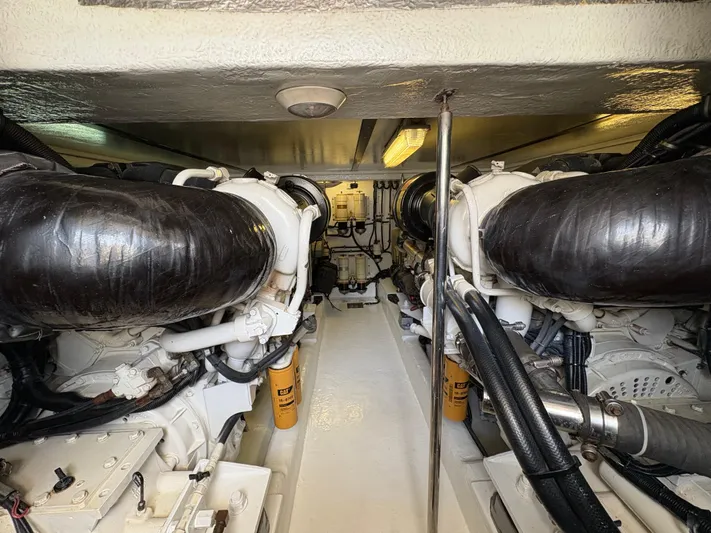 Obelix Yacht Photos Pics Engine room of a 2006 Riviera 60 Flybridge yacht, showcasing dual engines and mechanical components.