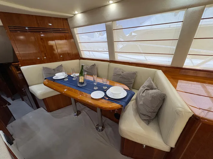 Obelix Yacht Photos Pics Luxurious dining area in 2006 Riviera 60 Flybridge yacht with elegant table setting.