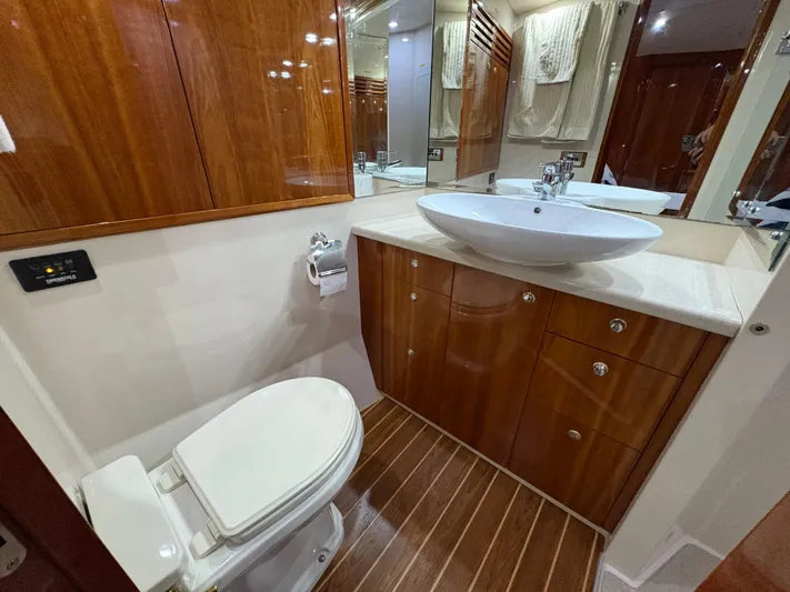 Obelix Yacht Photos Pics Luxurious bathroom in 2006 Riviera 60 Flybridge yacht with wooden cabinetry and modern fixtures.