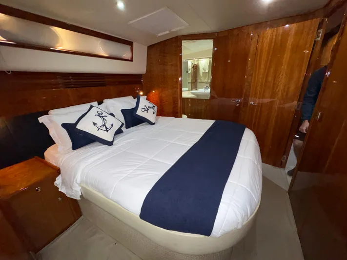 Obelix Yacht Photos Pics Luxurious bedroom interior of 2006 Riviera 60 Flybridge yacht with elegant wood finish.