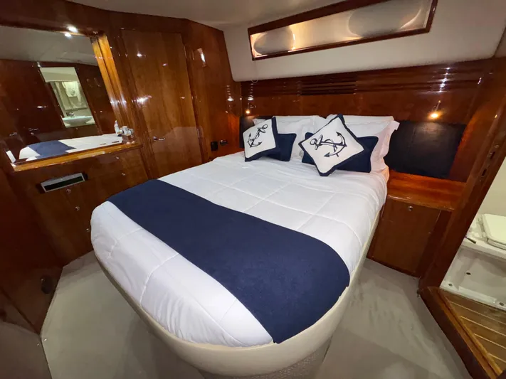 Obelix Yacht Photos Pics Luxurious bedroom interior of 2006 Riviera 60 Flybridge yacht with elegant wood finish.