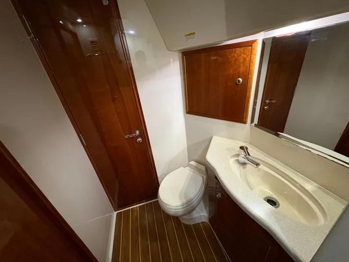 Obelix Yacht Photos Pics Luxurious bathroom in 2006 Riviera 60 Flybridge yacht with wooden accents and modern fixtures.