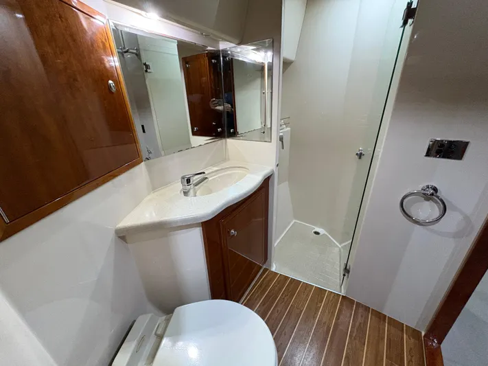 Obelix Yacht Photos Pics Luxurious bathroom in 2006 Riviera 60 Flybridge yacht with wood accents and modern fixtures.