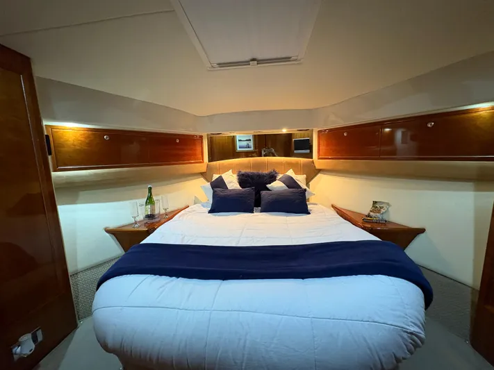 Obelix Yacht Photos Pics Luxurious bedroom interior of 2006 Riviera 60 Flybridge yacht with elegant wood accents.