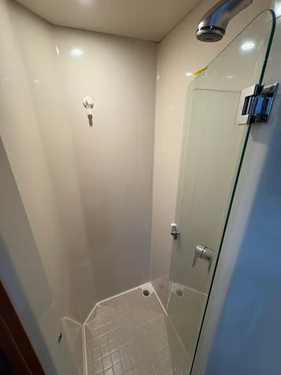 Obelix Yacht Photos Pics Shower area in 2006 Riviera 60 Flybridge yacht with glass door and modern fixtures.