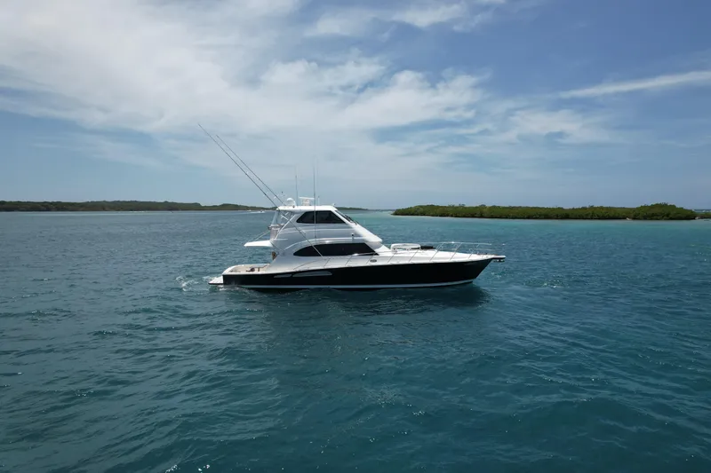 Obelix Yacht Photos Pics Riviera 60 Flybridge yacht from 2006 cruising on clear blue waters.