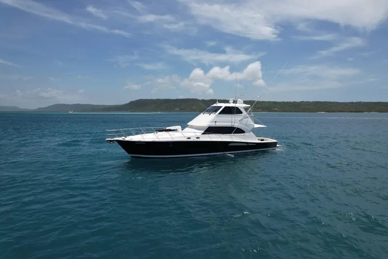 Obelix Yacht Photos Pics 2006 Riviera 60 Flybridge yacht on calm blue waters under a clear sky.