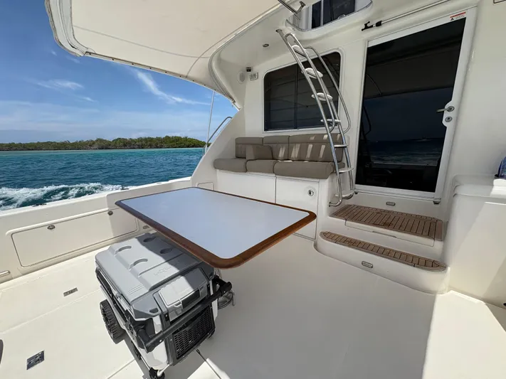 Obelix Yacht Photos Pics 2006 Riviera 60 Flybridge yacht deck with seating, table, and ocean view.